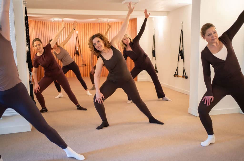 Groep vrouwen doet Essentrics oefening in studio.