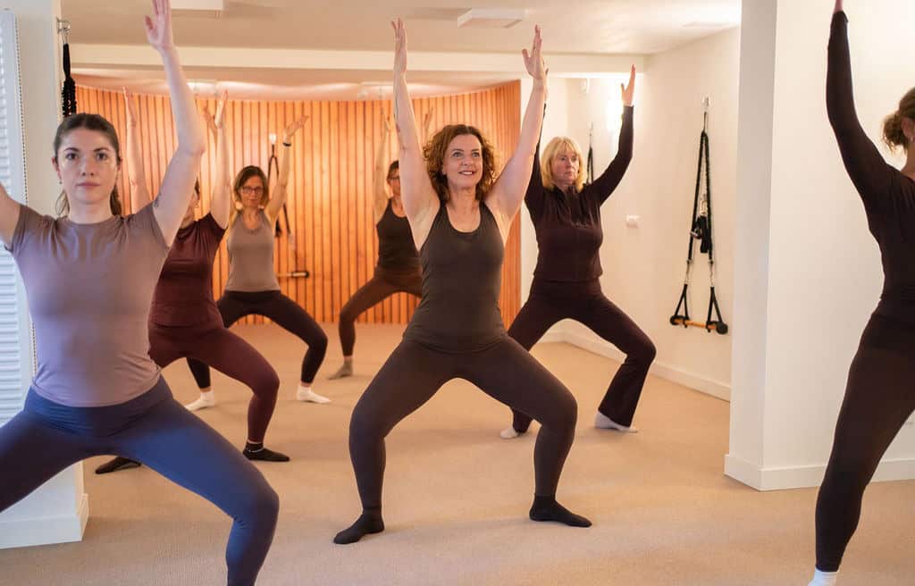 Groep vrouwen doet Essentrics oefening in studio.