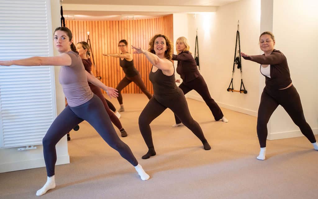 Groep vrouwen doet Essentrics oefening in studio.
