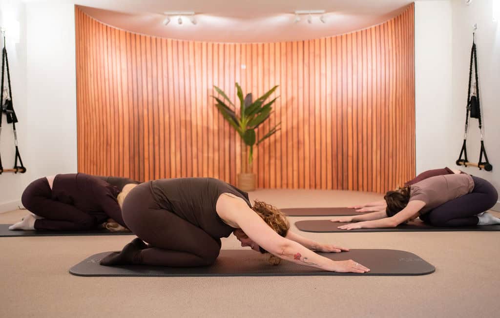 Mensen doen een ontspannende yoga- of somaticoefening in een rustige studio.