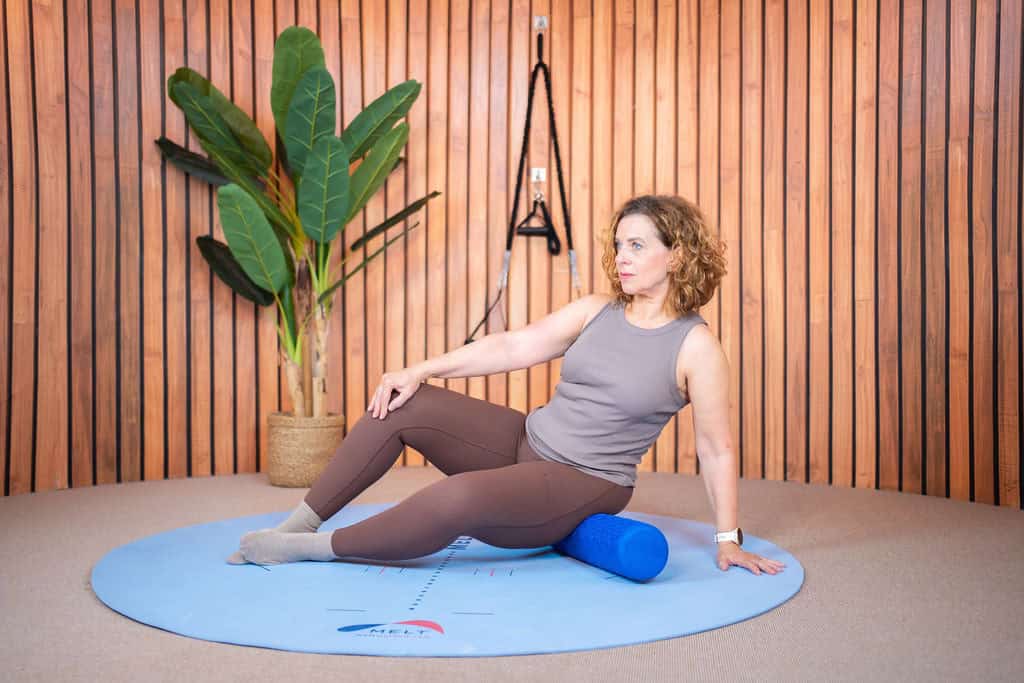 Vrouw oefent met foam roller voor Pilates en Essentrics training.